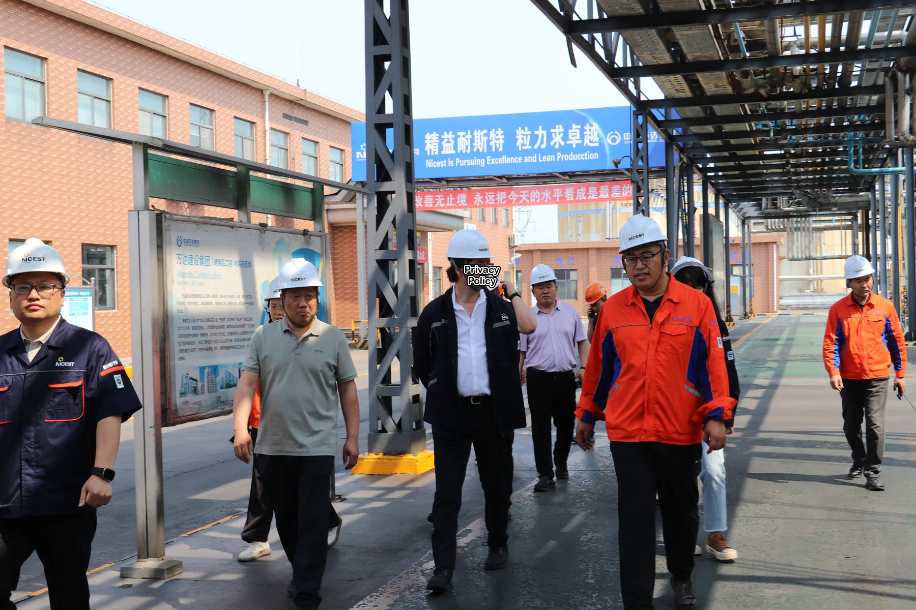 Overseas expert visiting an advanced materials production site with the local project team